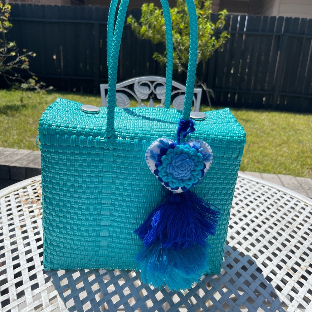 Teal weaved purse with tassel.
